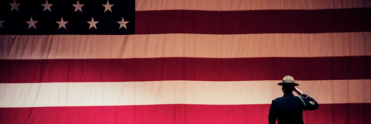 Silhouette of a man in front of the US flag.