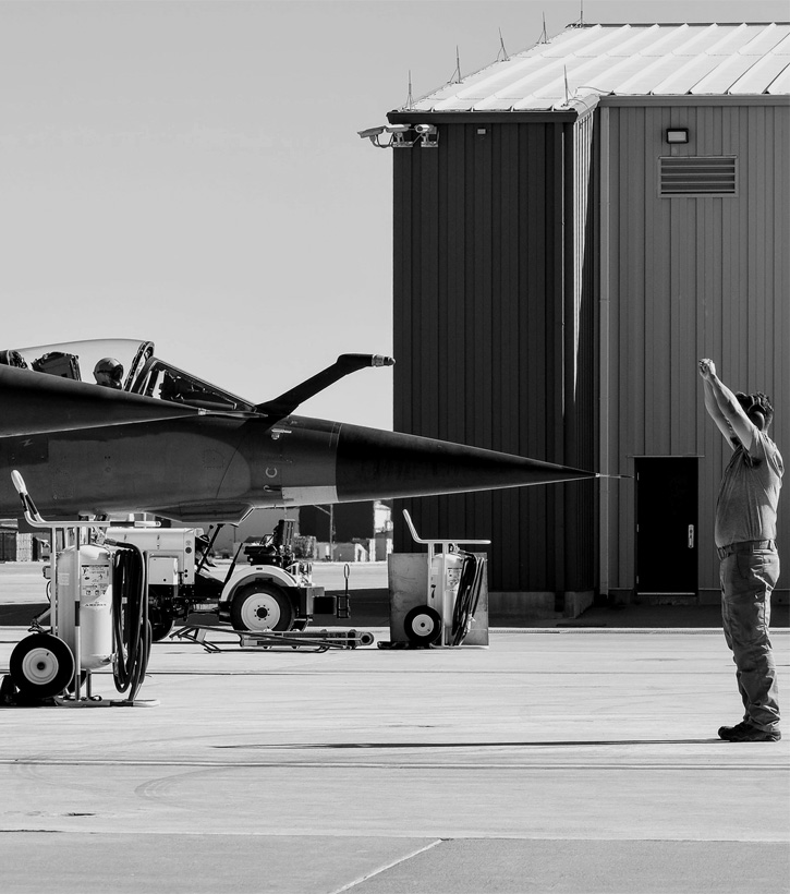 Ground staff giving directions to a fighter plane